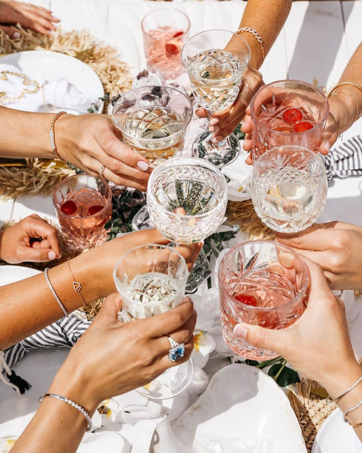People toasting with various cocktails at a social gathering.