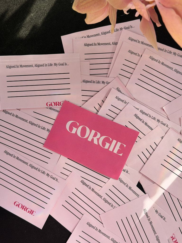 A stack of pink Gorgie-branded cards reading Aligned in Movement, Aligned in Life: My Goal Is, for wellness intention setting. - Sip & Social Club San Diego event