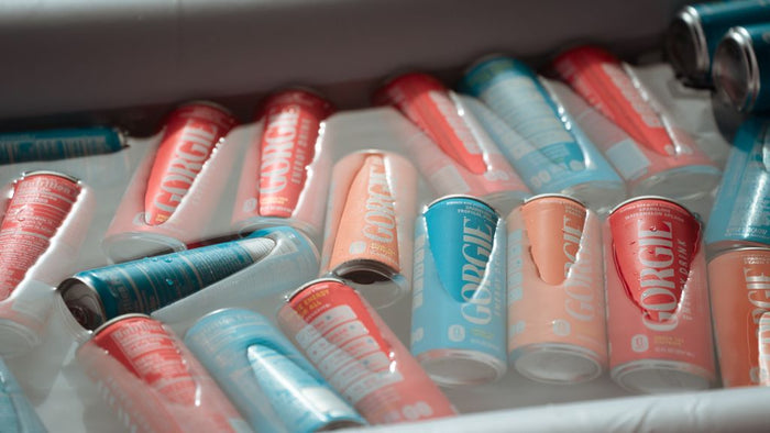 Multiple colorful cans of Gorgie wellness energy drinks cooling on ice for participants at a San Diego rooftop pilates class. - Sip & Social Club San Diego event