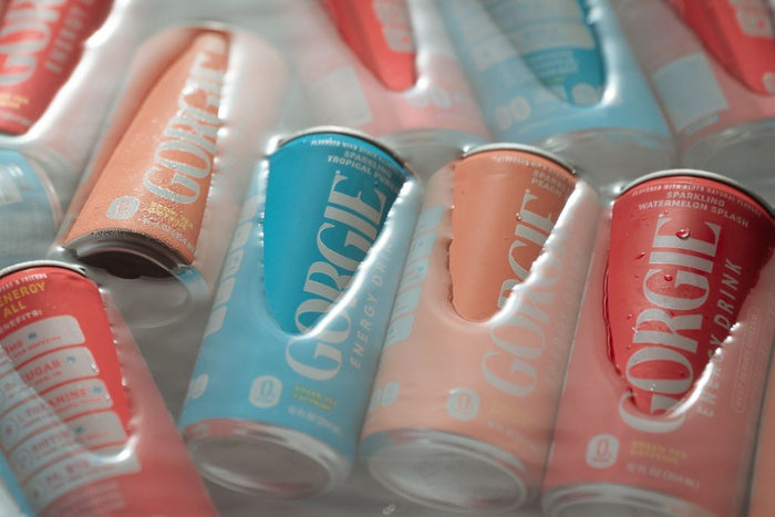 A row of colorful blue, pink, and orange Gorgie wellness energy drinks nestled on ice at a San Diego rooftop event. - Sip & Social Club San Diego event