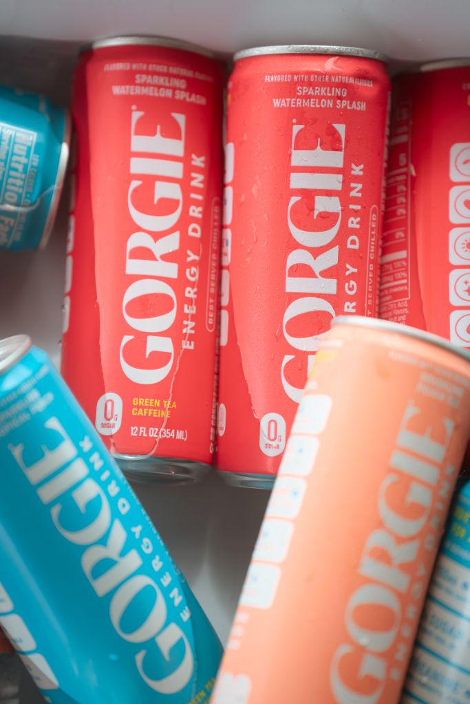 Close-up view of vibrant red Gorgie Watermelon Splash energy drink cans with condensation droplets. - Sip & Social Club San Diego event