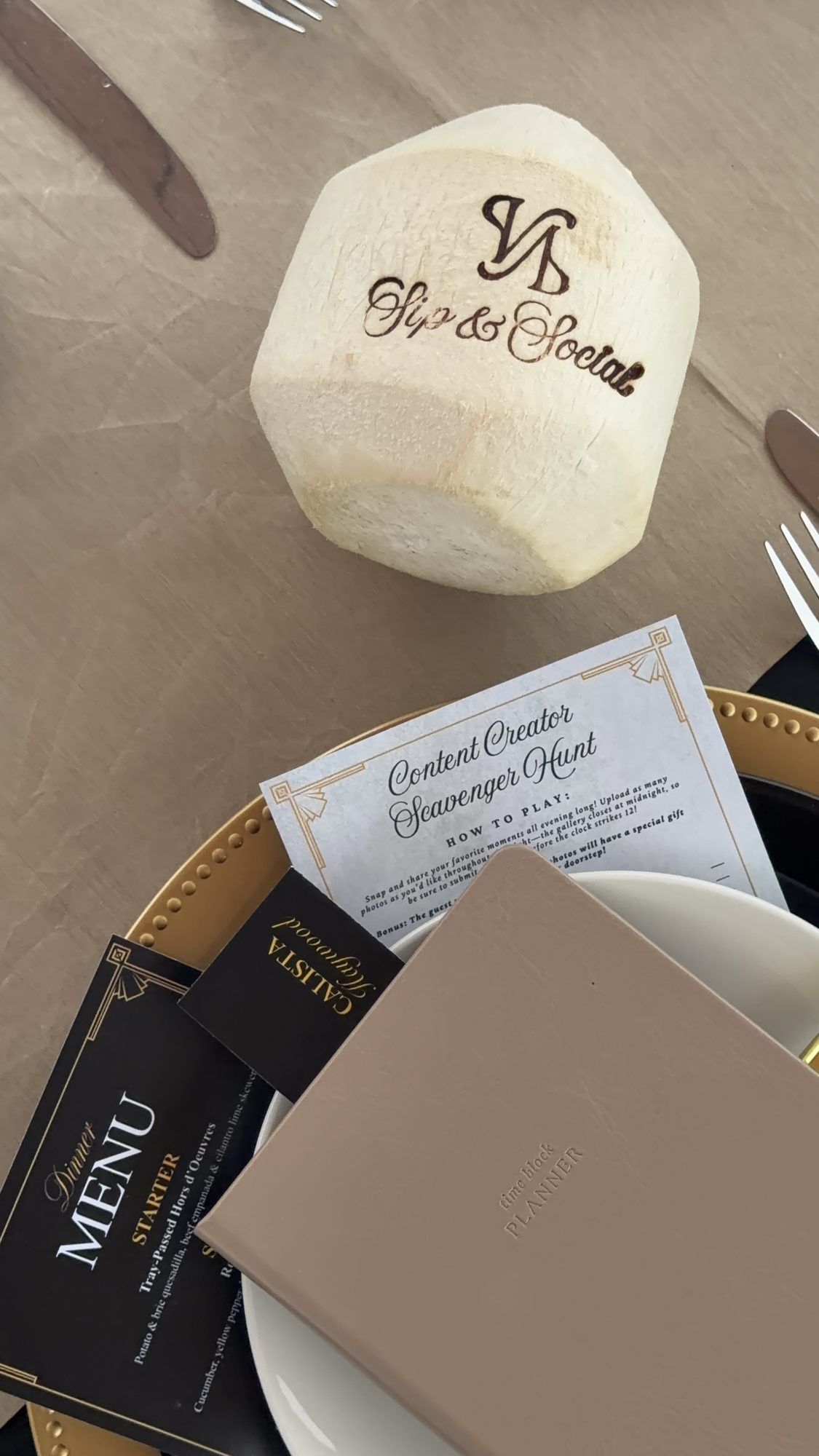 A dinner place setting with an engraved Sip and Social coconut and custom menus
