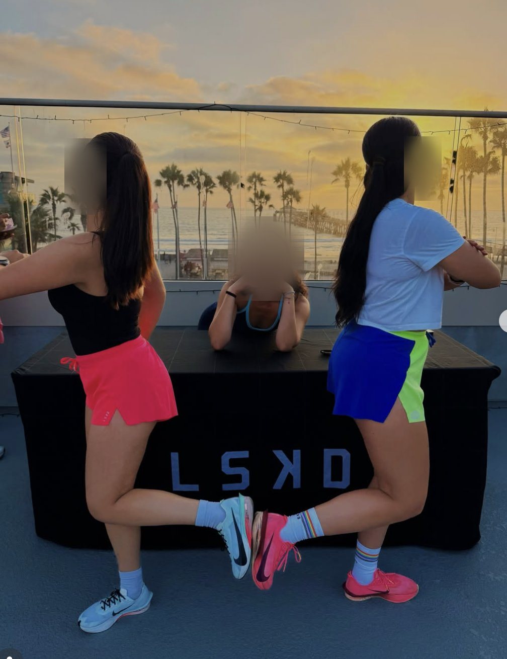 Guests posing at a branded LSKD table at sunset on the rooftop