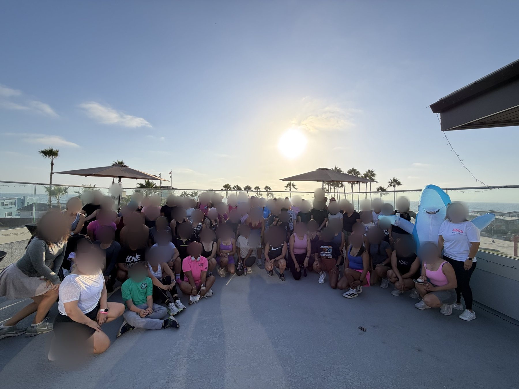 A huge run club group gathered on the rooftop at sunset
