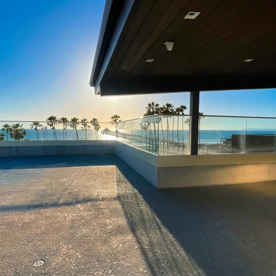 An empty oceanfront rooftop terrace looking out at the Imperial Beach Pier